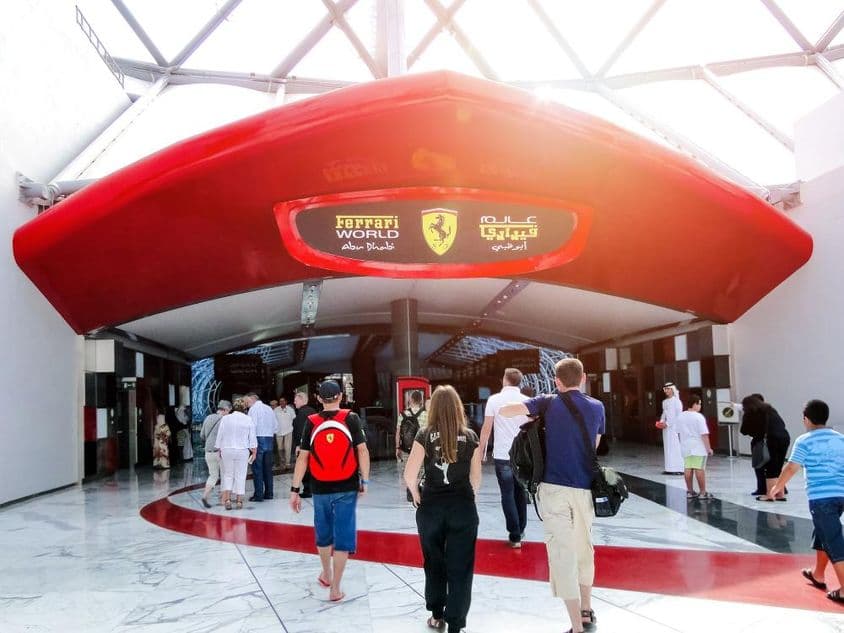 Entrada de la Arena de E-sports de Ferrari World en Abu Dhabi, gente entrando por la puerta.