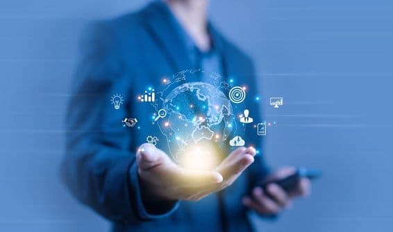 Una persona sosteniendo una proyección digital en forma de globo terráqueo.