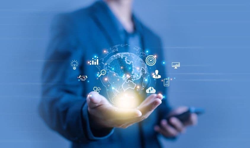 Una persona sosteniendo una proyección digital en forma de globo terráqueo.