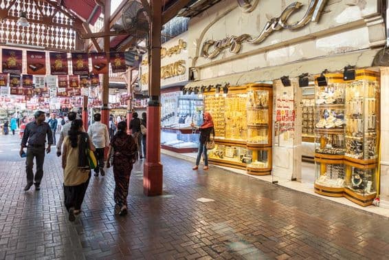 Mercado de oro de Dubái, una tienda mostrando joyería de oro, con personas paseando.