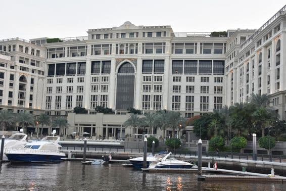 Hotel Palazzo Versace de Dubái, con lanchas motoras oscilando en el agua cerca.