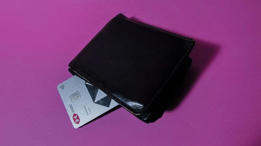Tarjeta de crédito HSBC en una billetera negra desgastada.