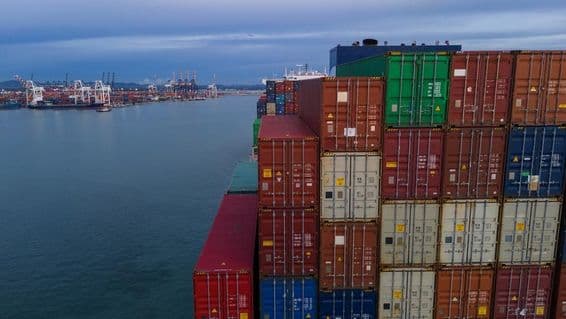 A la izquierda, se ve una bahía de un puerto marítimo, a la derecha contenedores apilados.