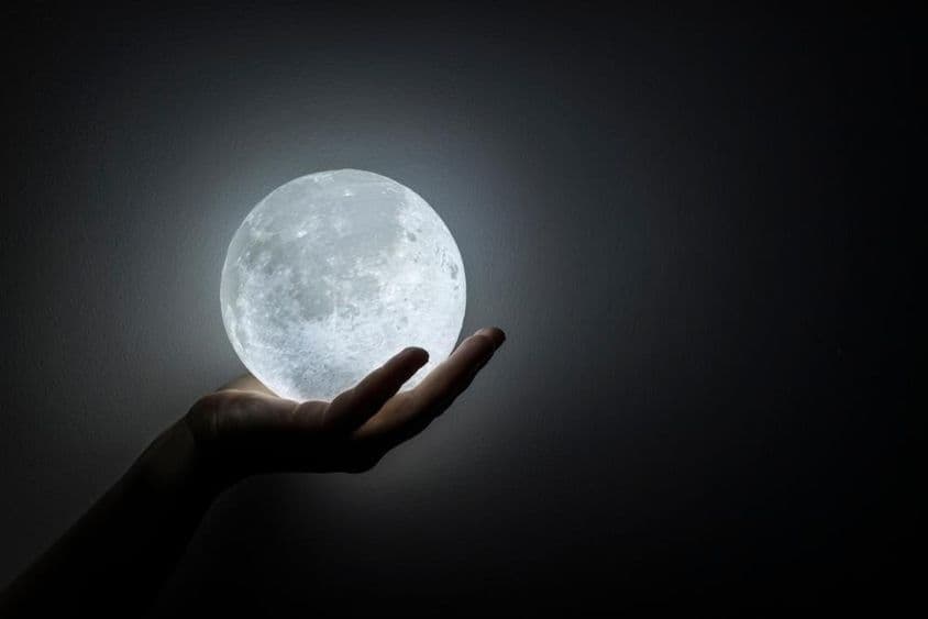 Una mano sosteniendo la luna.
