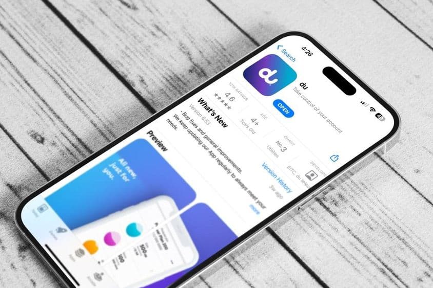 Un teléfono sobre una mesa, ejecutando la aplicación móvil de du.