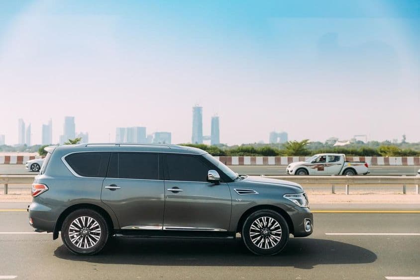 Nissan Patrol en primer plano con rascacielos de Dubái en el fondo.