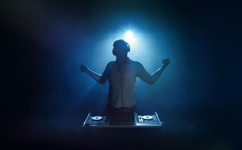 Una persona detrás de la cabina del DJ.