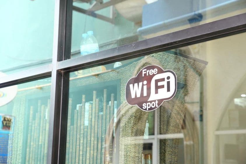 Cartel en ventana de café anunciando WiFi gratis.