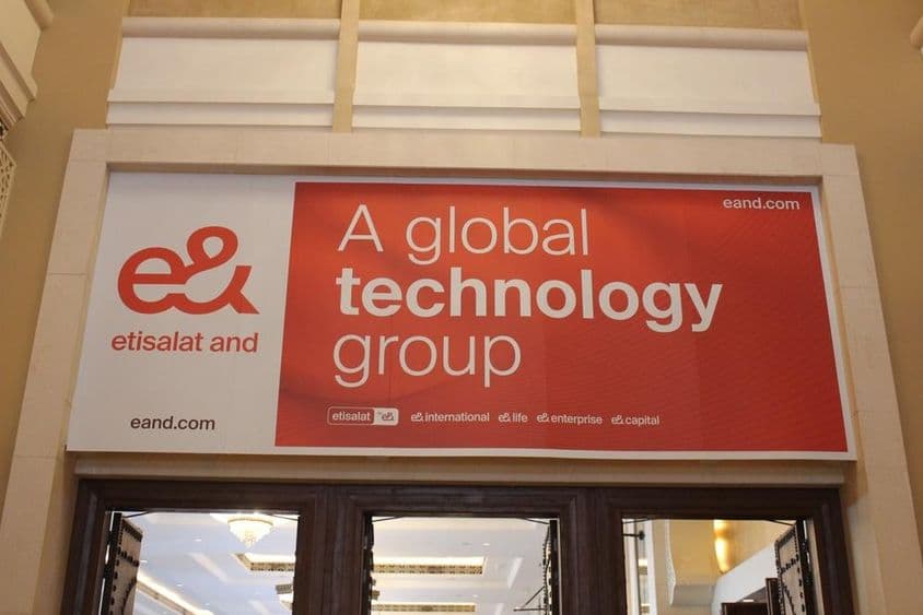 Anuncio de la compañía Etisalat sobre un escaparate con entrada de vidrio visible.