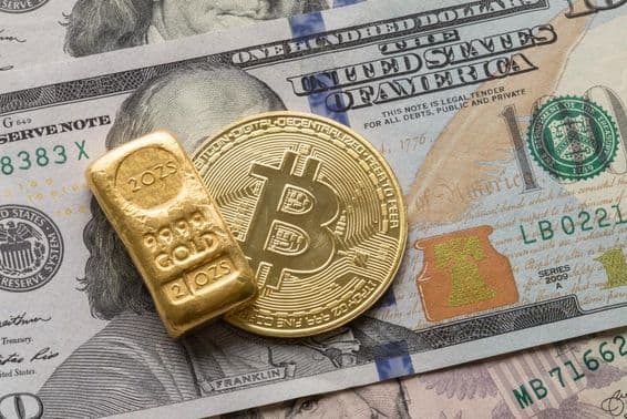 Una barra de oro de inversión y una moneda de Bitcoin sobre un billete de 100 dólares.