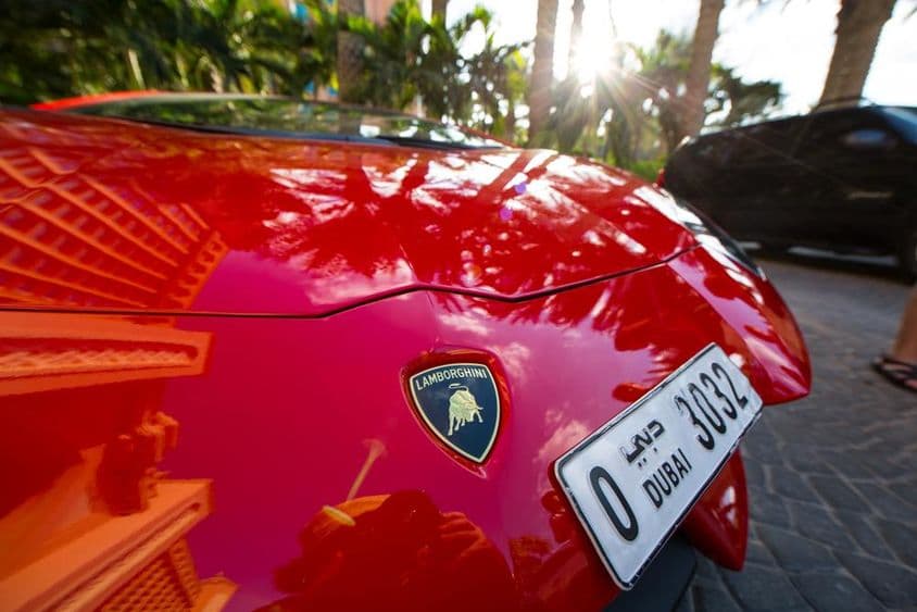 Un Lamborghini rojo mostrando una placa de matrícula de cuatro dígitos de Dubái.