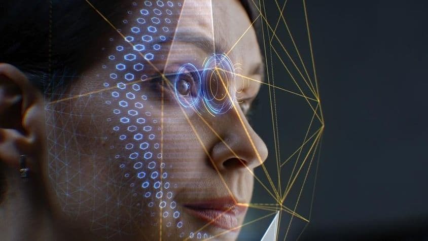 Una mujer mirando un sistema de reconocimiento facial.