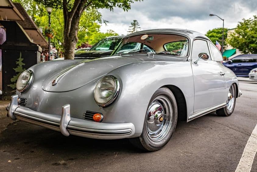 Un Porsche 356A se ve estacionado bajo un árbol.