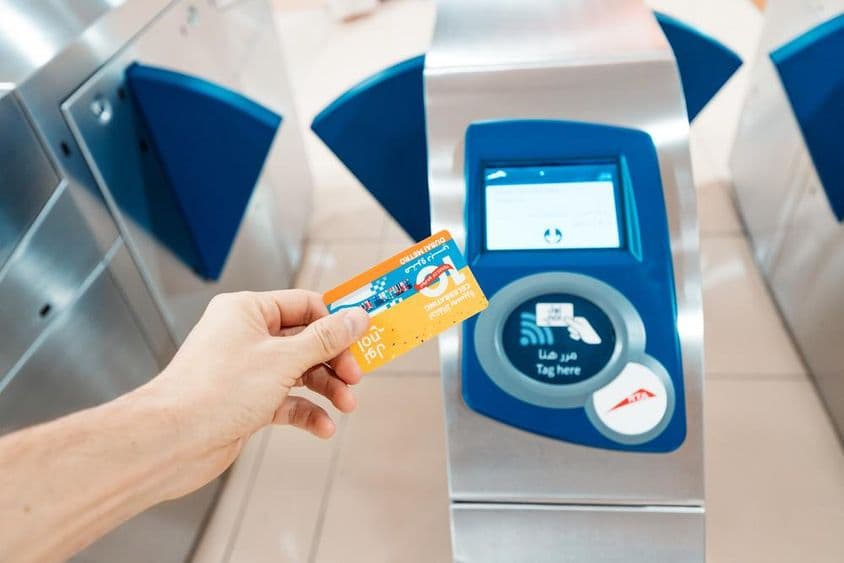 Una persona sosteniendo una tarjeta Nol edición limitada del 10º aniversario en uso en el metro.