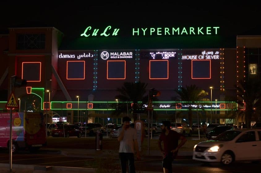 Entrada del hipermercado LuLu con neón visible arriba.