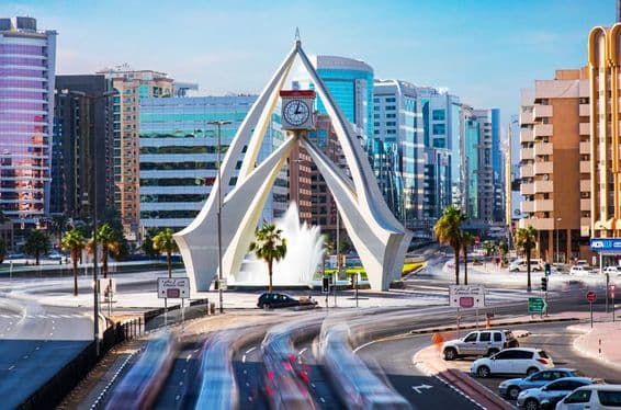 La Asombrosa Torre del Reloj en Dubái con casas de fondo.