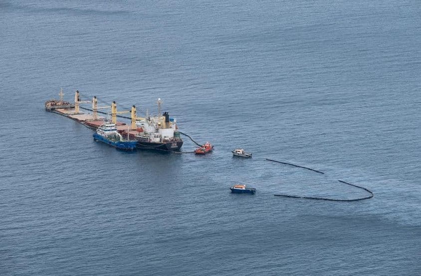 Limpieza de derrame de petróleo en el mar, barcos rodeando el área.