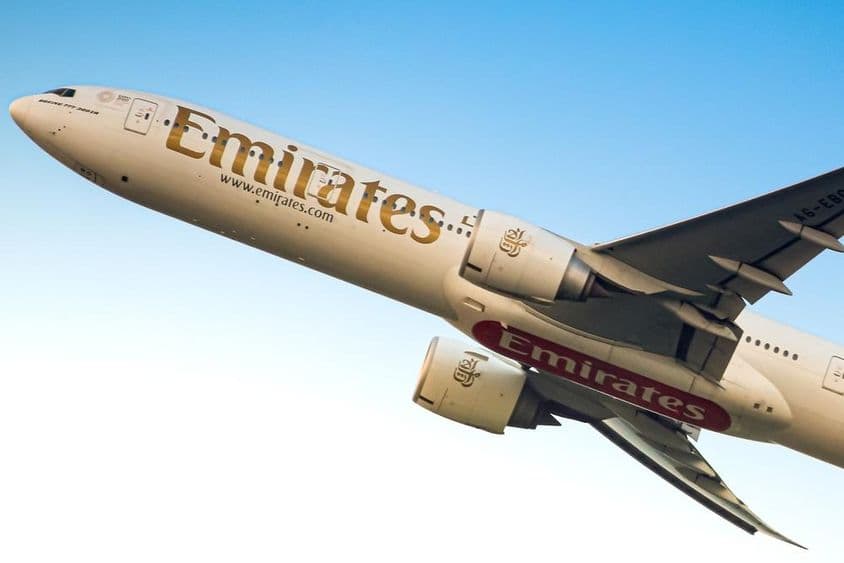 Avión de Emirates en el cielo, visible desde abajo.