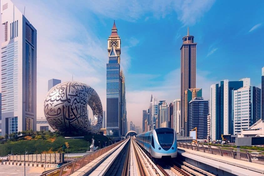 Metro de Dubái con rascacielos al fondo, museo del futuro a la izquierda.