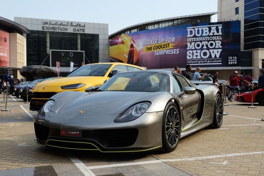 Porsche en primer plano junto a un Lambo.