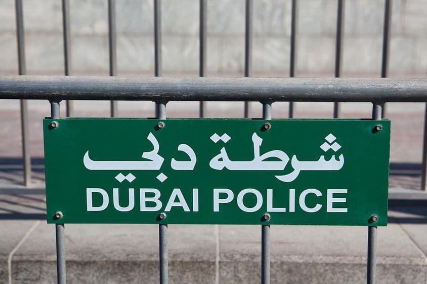Señal de la Policía de Dubái visible en una cerca.