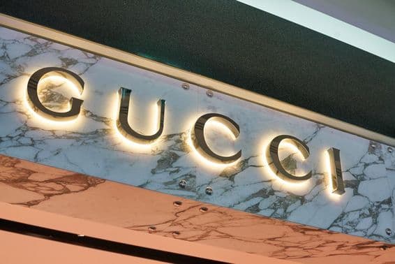 Letrero de Gucci en letras iluminadas en la fachada de una pared.
