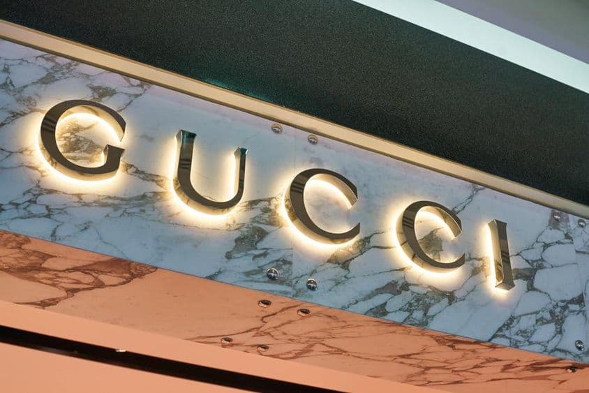 Letrero de Gucci en letras iluminadas en la fachada de una pared.