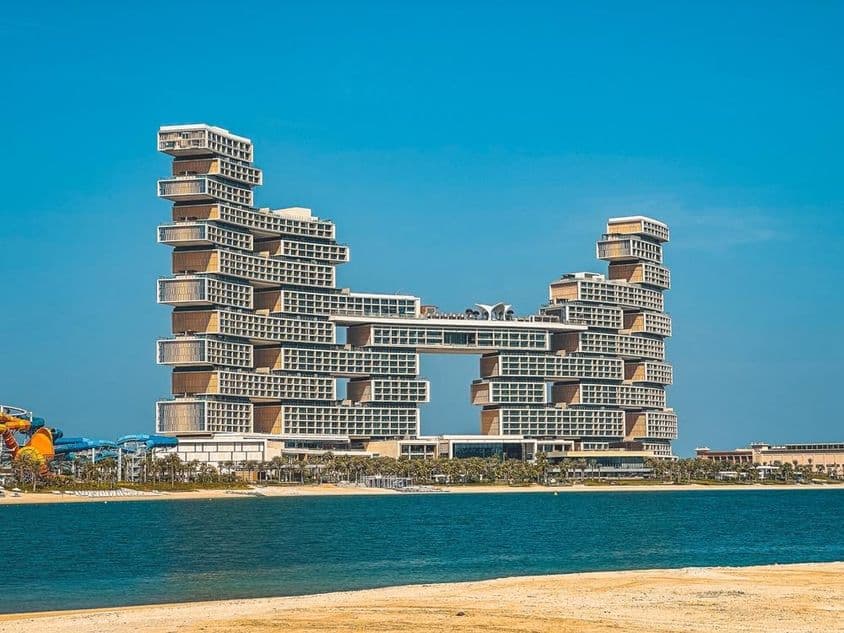 Hotel Atlantis The Royal al fondo con agua y playa en primer plano.