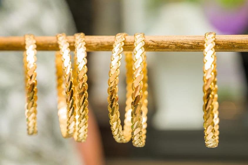 Brazaletes de oro de 24 quilates ensartados en una varilla.