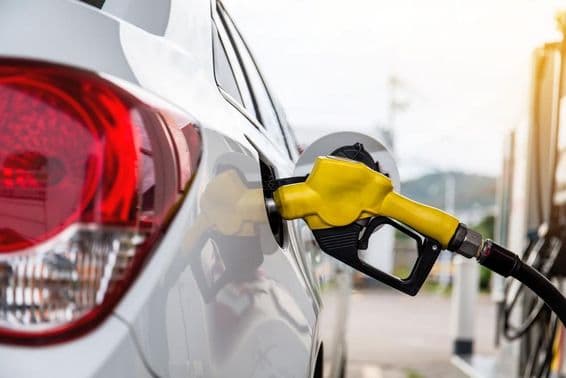 Boquilla de combustible insertada en la abertura de llenado de un coche.