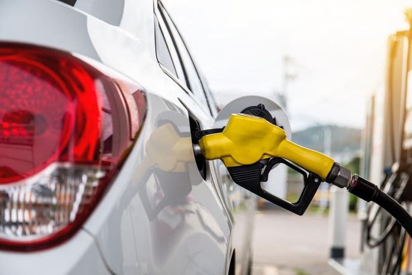Boquilla de combustible insertada en la abertura de llenado de un coche.