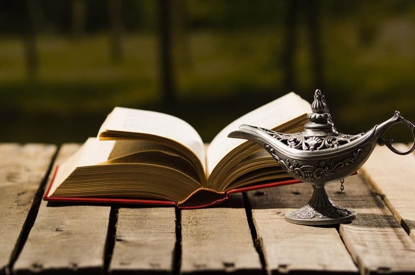 Libro abierto y lámpara antigua.