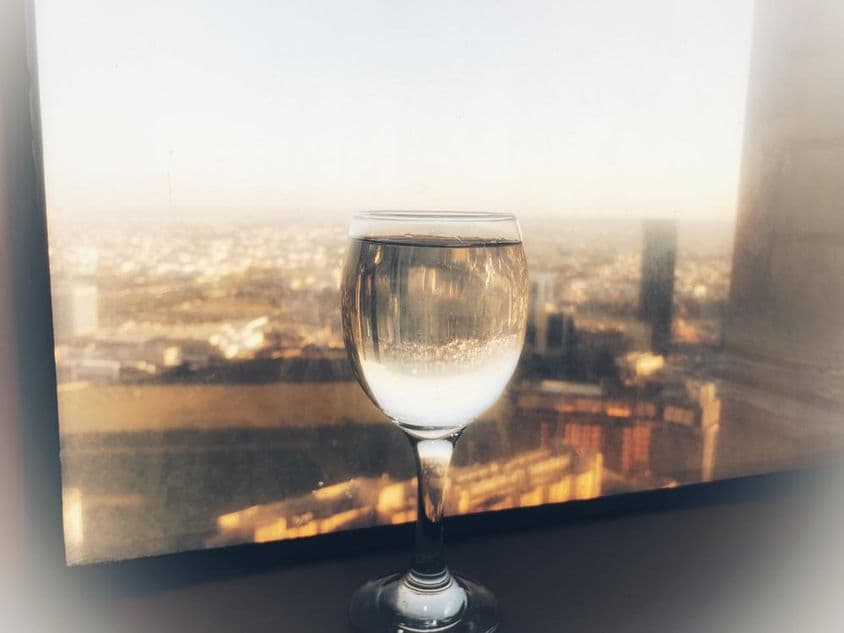Una copa de vino en la ventana con vista a la ciudad.