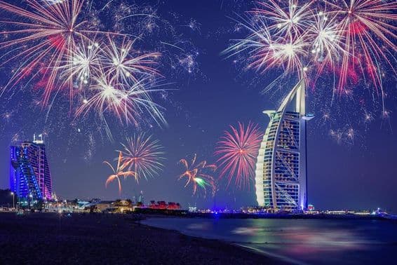 Nochevieja en Dubái con el Burj Al Arab y fuegos artificiales de fondo.
