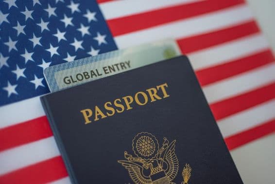 Pasaporte estadounidense con una bandera estadounidense de fondo.
