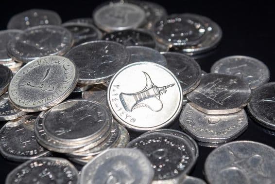 Un puñado de monedas de 1 dírham esparcidas.
