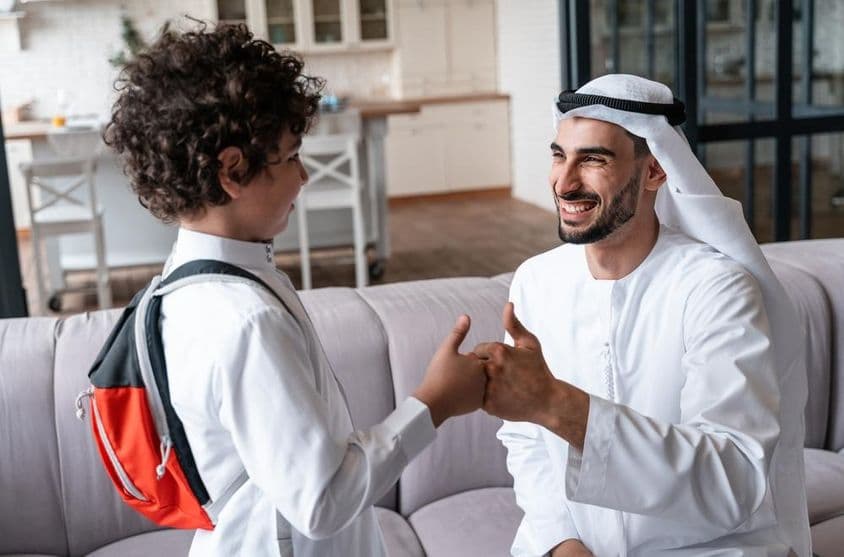 Un padre e hijo árabes preparándose para la escuela.