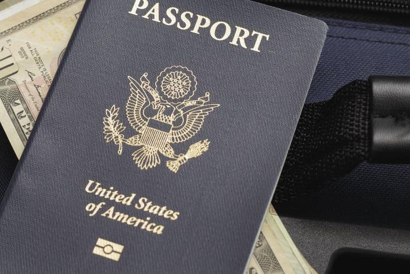 Pasaporte estadounidense descansando sobre dólares.