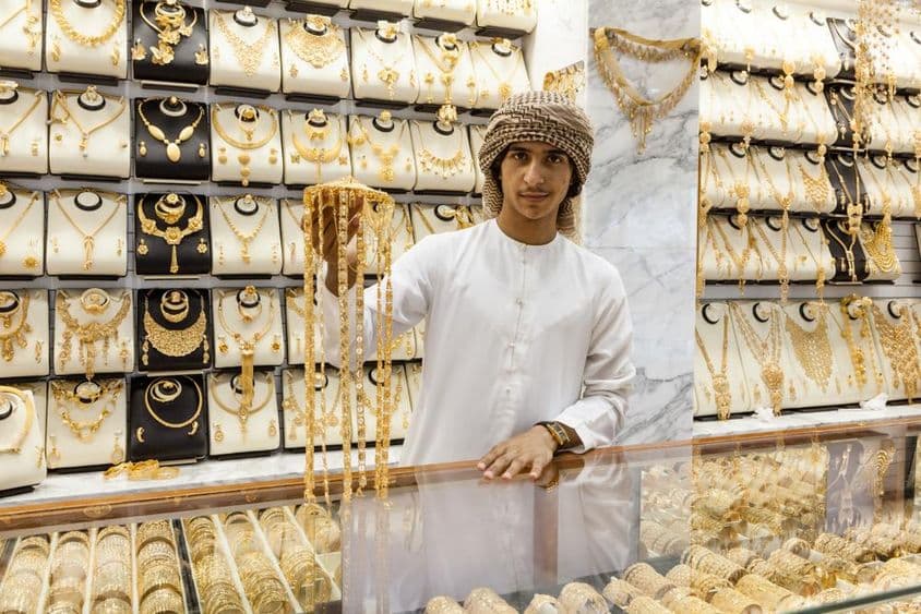 Niño árabe muestra oro en una tienda.