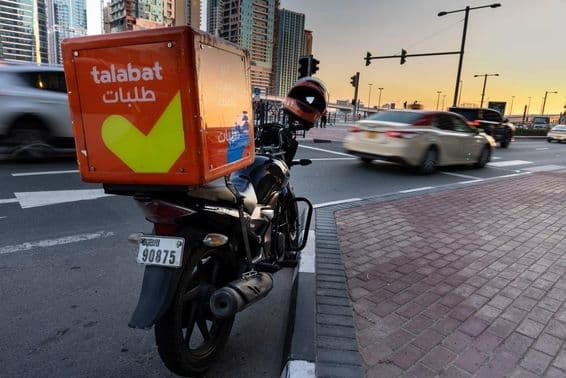 Motocicleta de Talabat estacionada al borde de la carretera.
