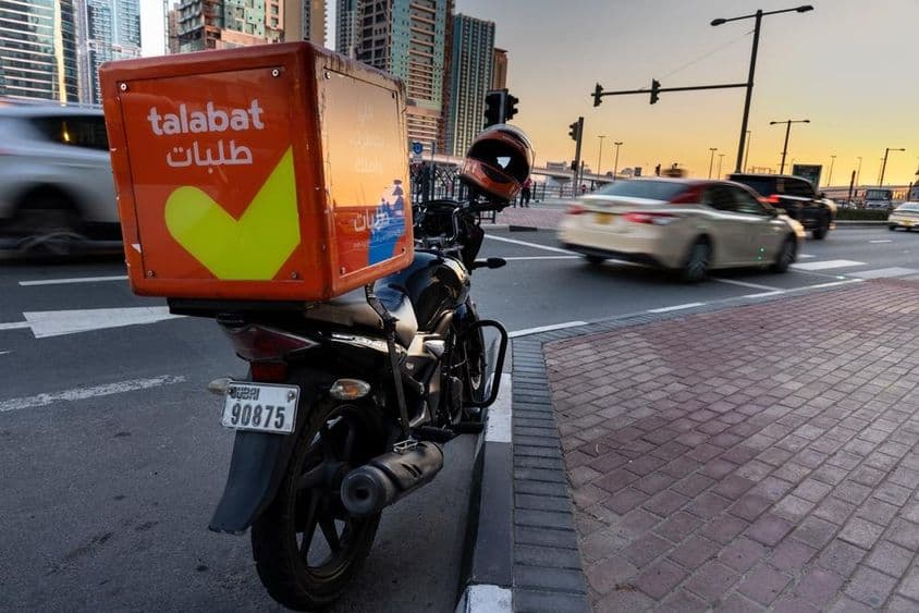 Motocicleta de Talabat estacionada al borde de la carretera.