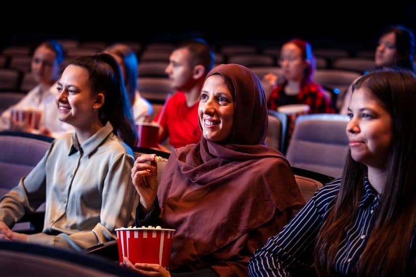 Mujer musulmana disfrutando en el cine.