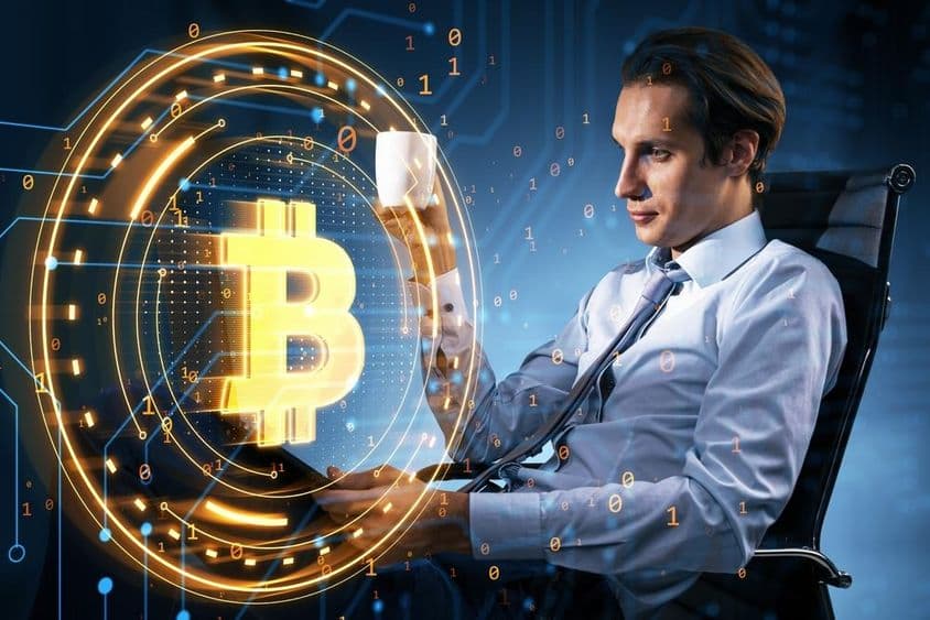 Empresario sosteniendo una taza de café mira el precio de Bitcoin.
