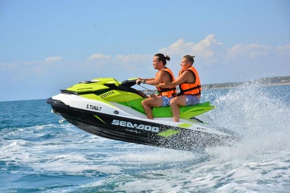 Pareja joven sentada en un jet ski.