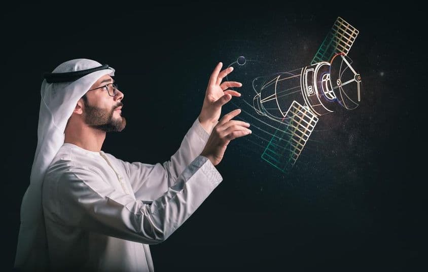 Hombre musulmán frente a satélite proyectado.