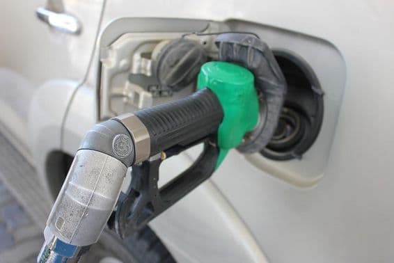 Repostando en una estación de servicio a un coche blanco.