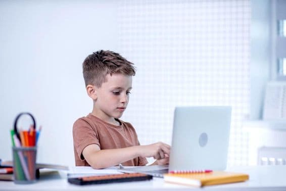 Escolar aprendiendo con una computadora.
