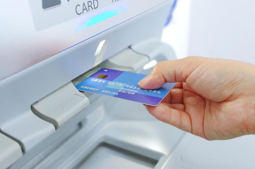 Retiro de efectivo en un cajero automático con tarjeta bancaria.