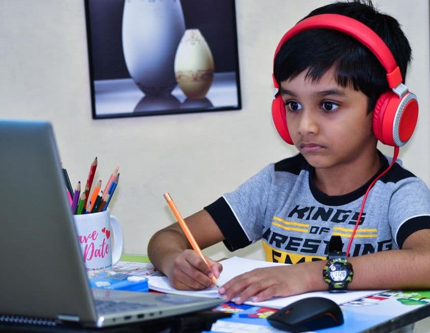 Escolar escribiendo una lección en escuela de Sharjah.