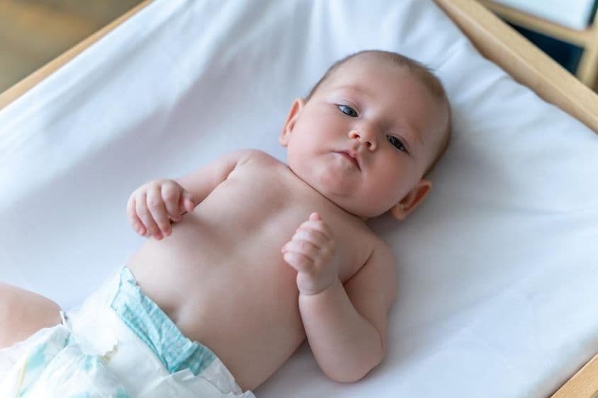 Bebé blanco acostado en un pañal.